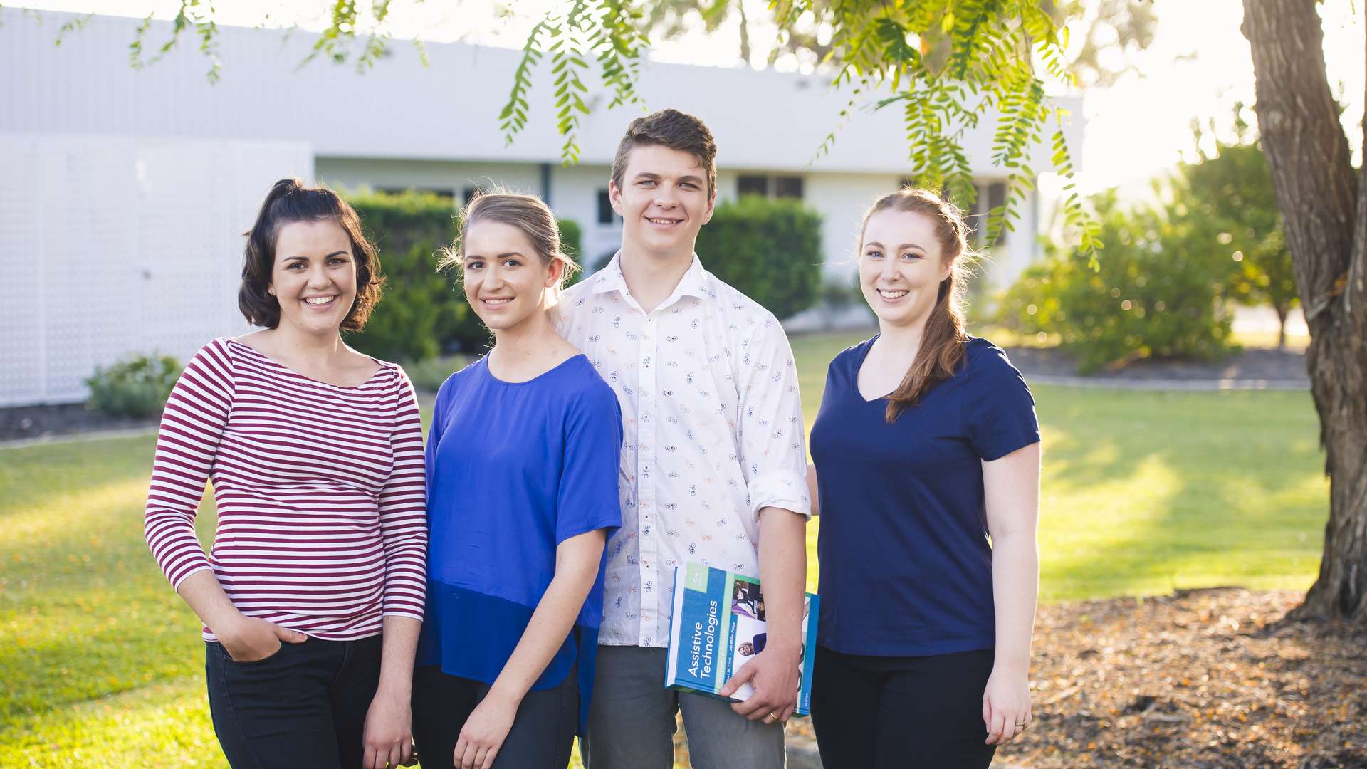 Four students standing under a tree on Bundaberg campus