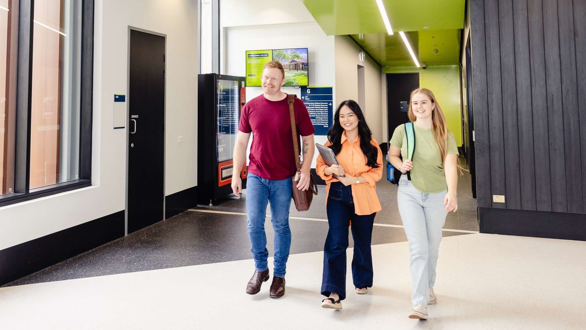 Three CQU students walk together through an on-campus building.