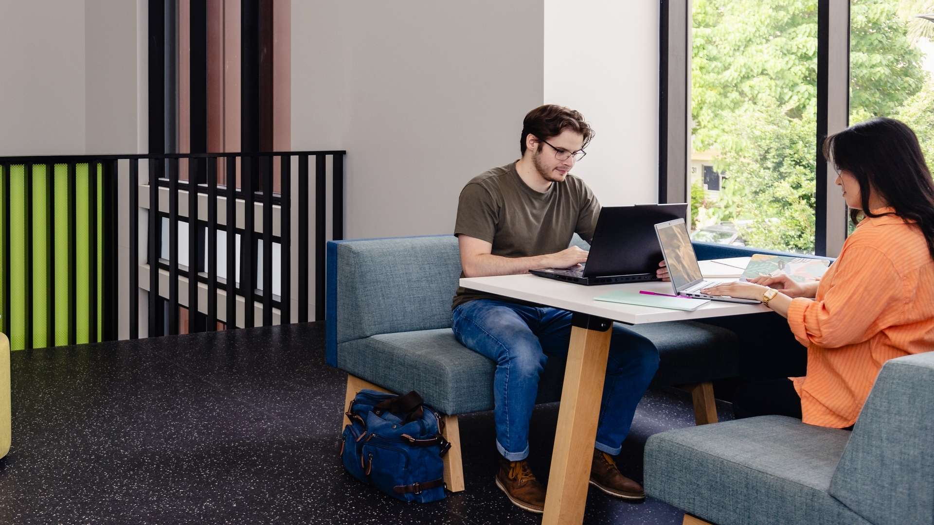 CQU students study together at tables in an open plan area on campus.