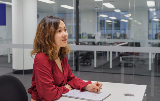 International student attending a class with a notebook and pen
