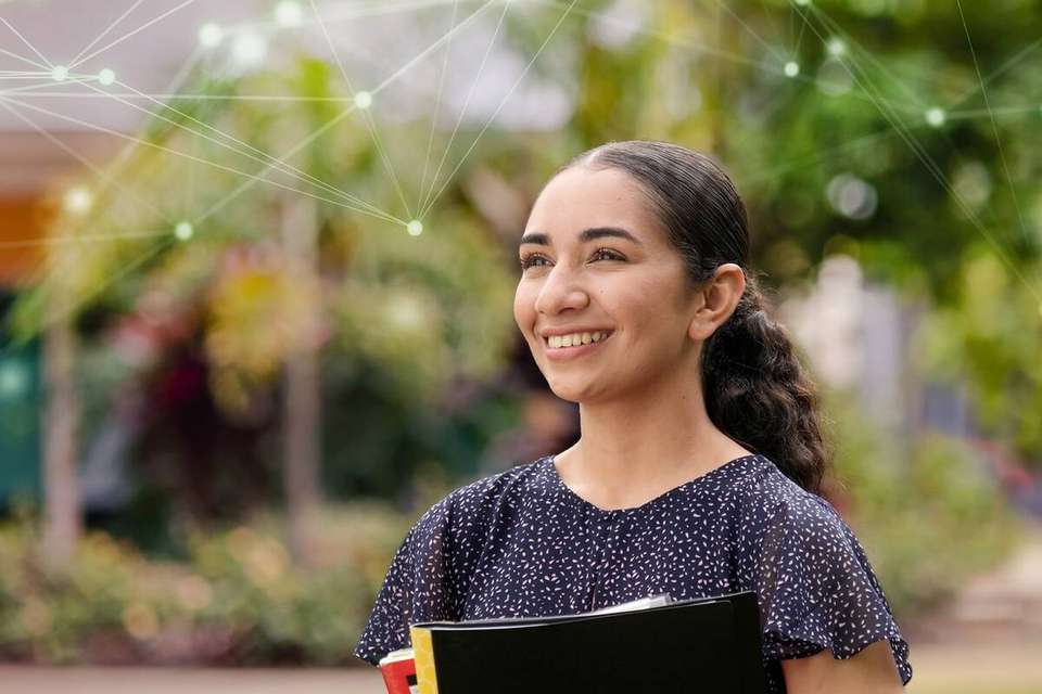 Tyla stands on campus looking into the distance with digital web graphics super imposed on the image.