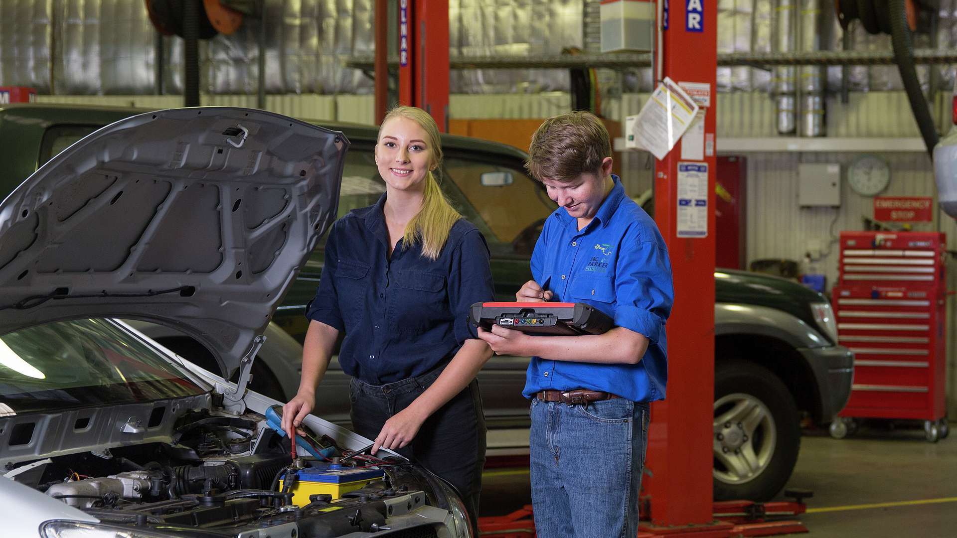 CQU TAFE students work on car engine in automotive workshop.