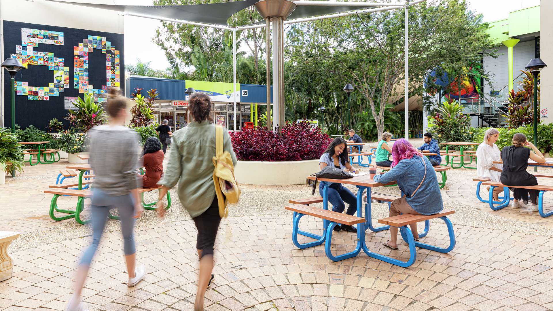 Rockhampton students studying, walking and chatting in the campus courtyard