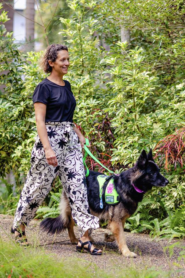 A CQU staff member walks through campus with a support dog.