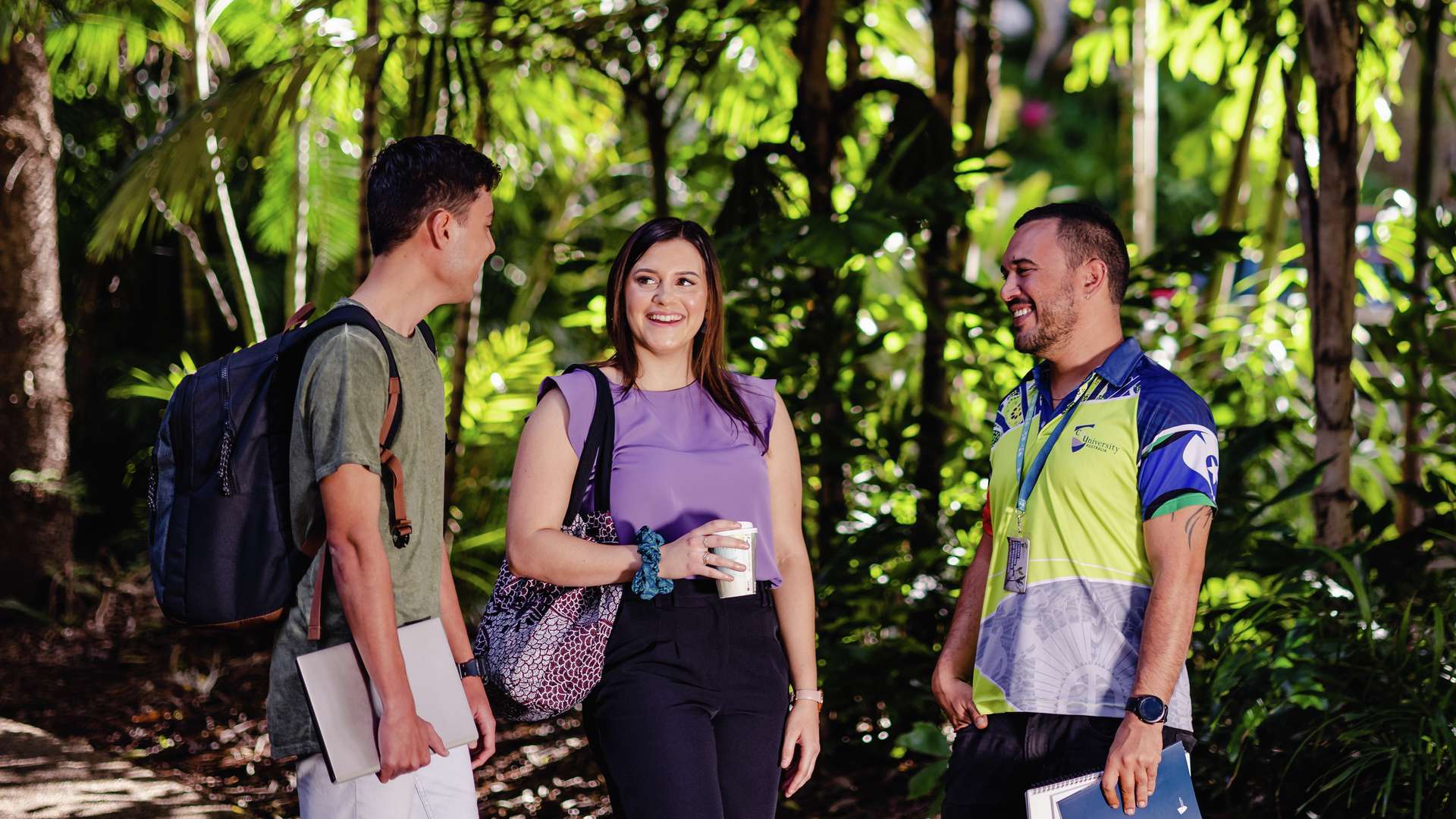 First Nations students standing and chatting on a path in a tropical rainforest