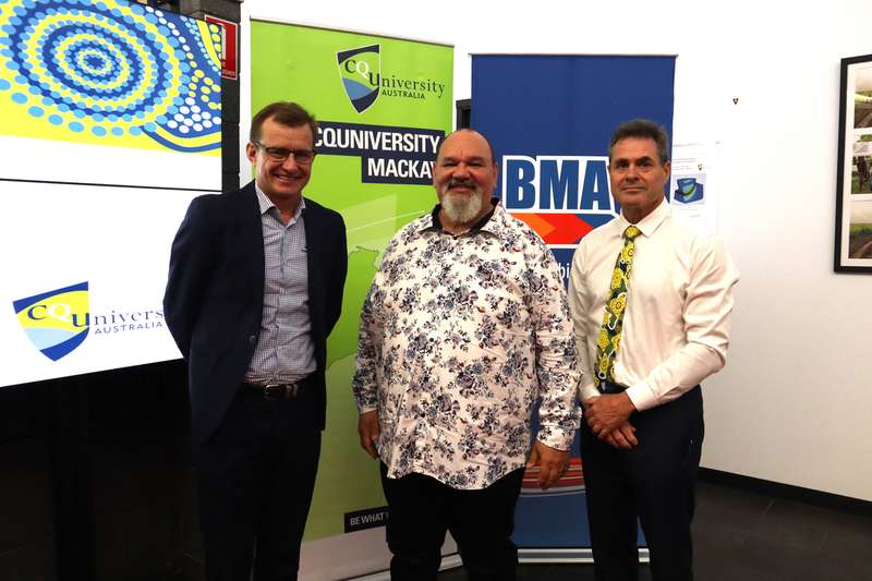 Mr Steve Johnson (BMA), Prof Adrian Miller (CQU) and Prof Grant Stanley (CQU) standing together infront of a CQU and a BMA pull up banner